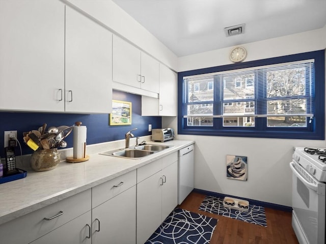 kitchen featuring visible vents, dark wood-type flooring, light countertops, white appliances, and a sink