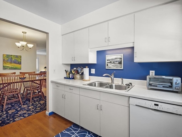 kitchen featuring a sink, wood finished floors, white cabinets, light countertops, and dishwasher