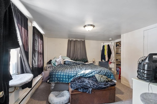 carpeted bedroom featuring a baseboard radiator and a closet