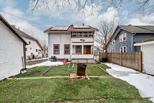 90 Rochelle St, Springfield, MA 01109 - rear view of property featuring solar panels, fence, and a lawn