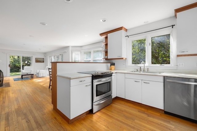 kitchen with light hardwood / wood-style flooring, stainless steel appliances, a healthy amount of sunlight, and white cabinetry