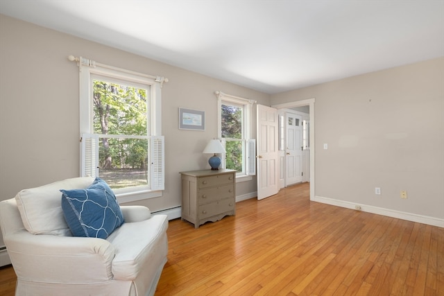 living area with a baseboard radiator and light hardwood / wood-style floors