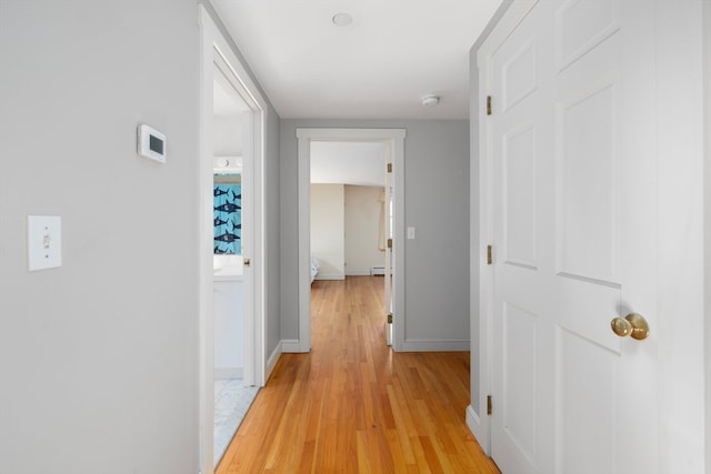 hallway with a baseboard radiator and light hardwood / wood-style floors