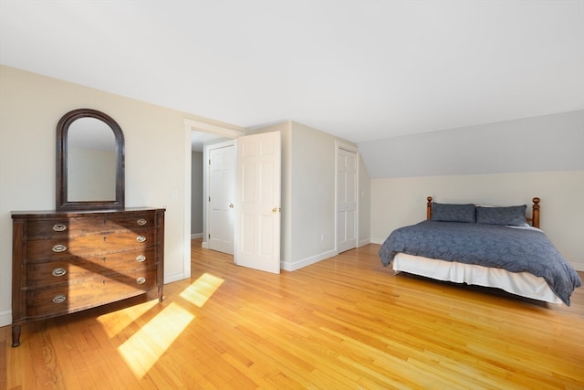 bedroom with lofted ceiling and light hardwood / wood-style floors