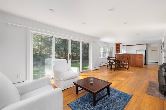 living room featuring light wood-type flooring and baseboard heating