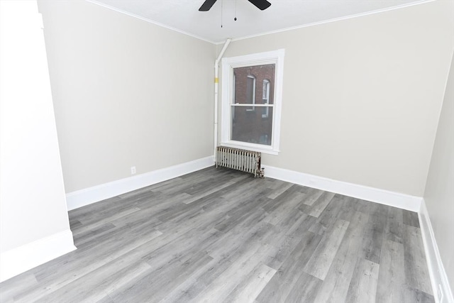 unfurnished room with crown molding, ceiling fan, radiator, and light hardwood / wood-style floors