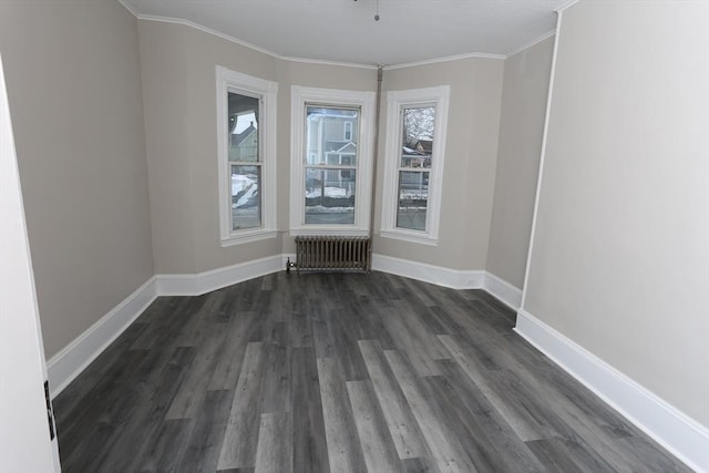 spare room with dark wood-type flooring, radiator heating unit, and ornamental molding