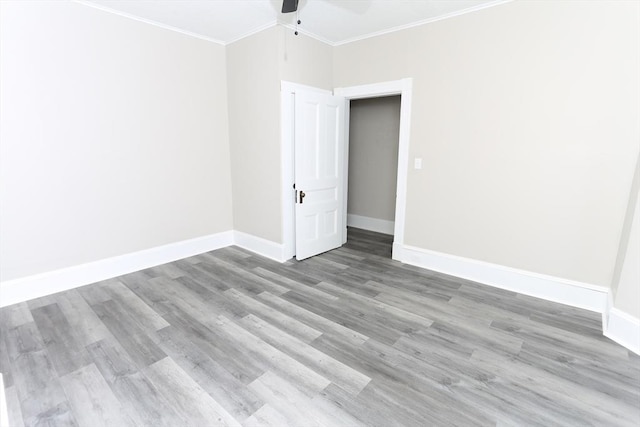 unfurnished room with ornamental molding, ceiling fan, and light wood-type flooring