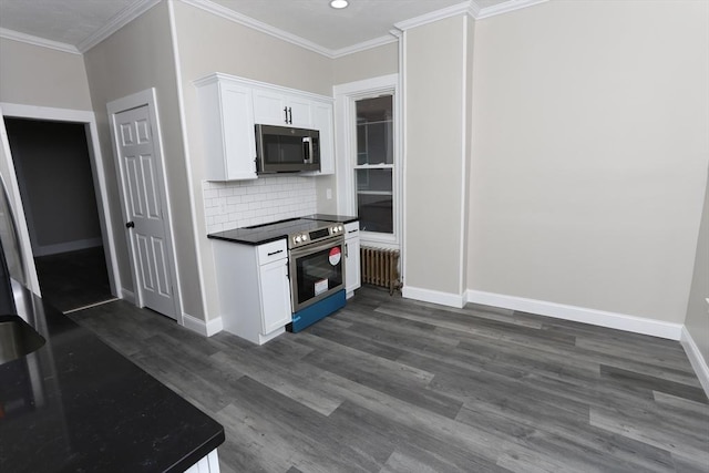 kitchen with decorative backsplash, radiator heating unit, white cabinets, and appliances with stainless steel finishes