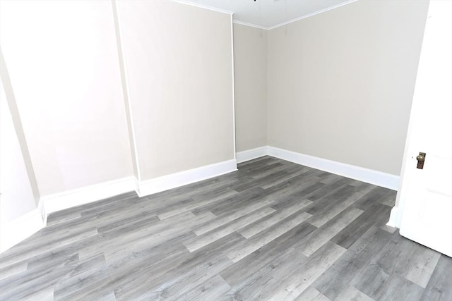 empty room with crown molding and wood-type flooring