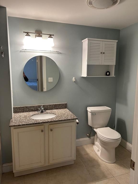 bathroom with vanity, toilet, and tile patterned flooring