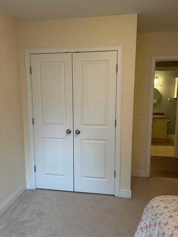 bedroom with light colored carpet and a closet