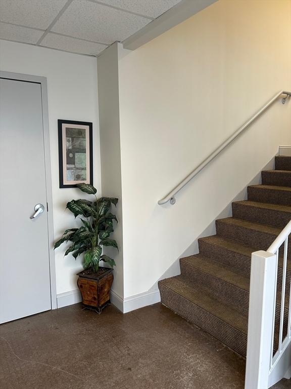 stairs featuring a drop ceiling