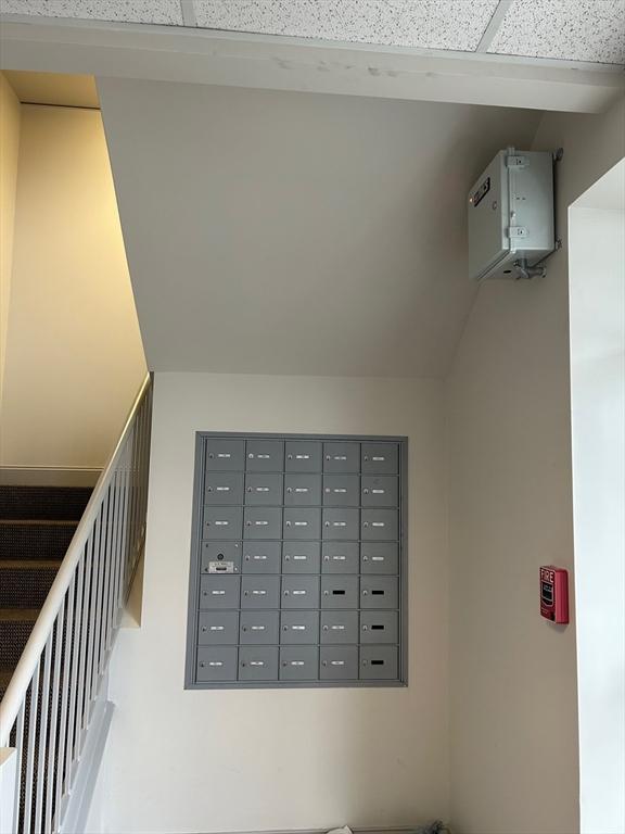 stairway featuring a paneled ceiling and mail boxes