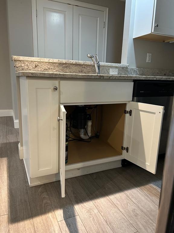 details featuring white cabinetry, light stone countertops, and light wood-type flooring