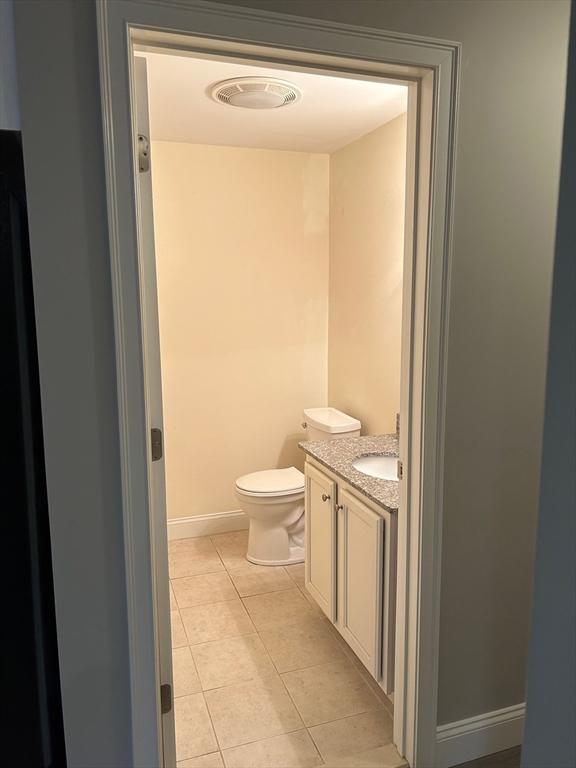 bathroom featuring tile patterned flooring, vanity, and toilet