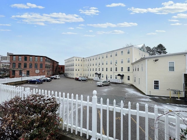 view of property featuring uncovered parking and fence