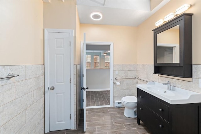 bathroom featuring a baseboard radiator, wood finish floors, tile walls, and toilet