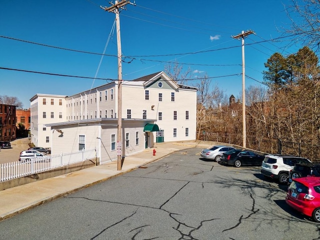 exterior space featuring uncovered parking and fence