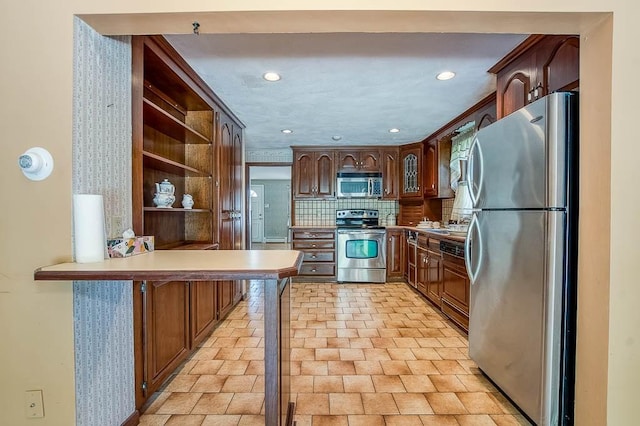 16 Miriam Dr, Attleboro, MA 02703 - kitchen featuring appliances with stainless steel finishes, a peninsula, open shelves, light countertops, and decorative backsplash