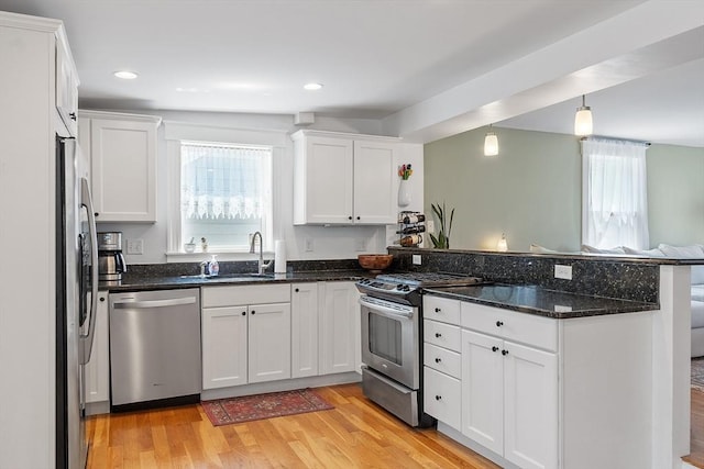 15 Hardy St Unit 2, Salem, MA 01970 - kitchen with stainless steel appliances, a sink, a peninsula, white cabinetry, and recessed lighting