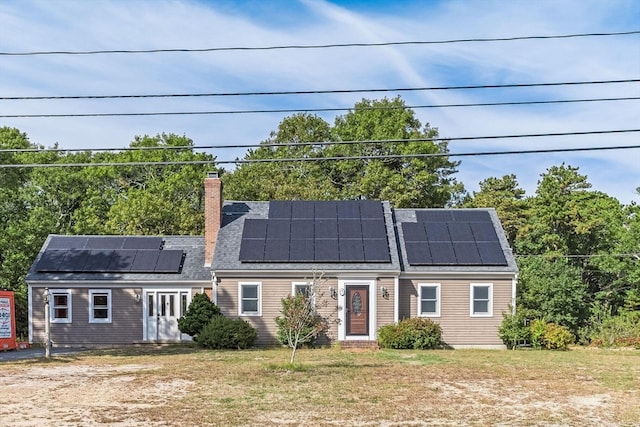 view of front of house with a front yard and solar panels