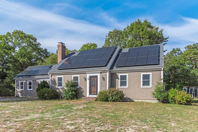 back of house with a yard and solar panels