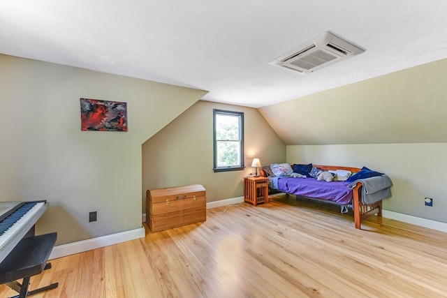 bedroom featuring light wood-type flooring and lofted ceiling