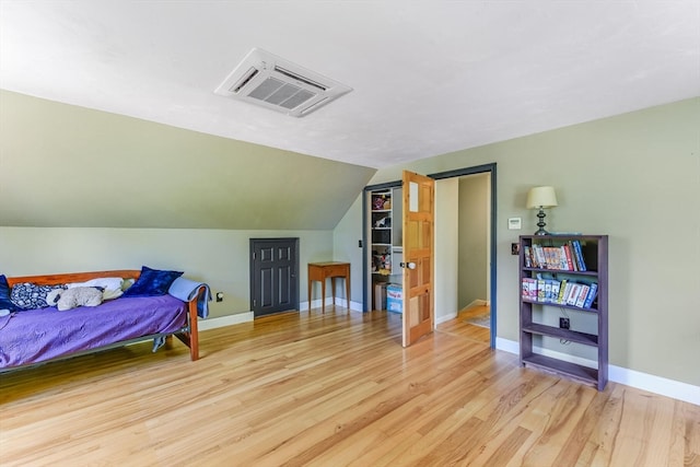 bedroom featuring light wood-type flooring and vaulted ceiling