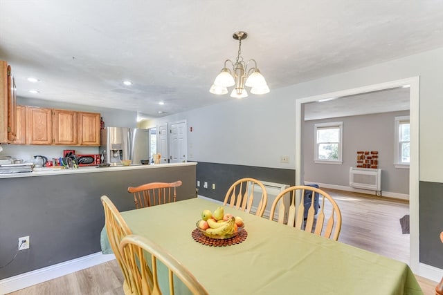 dining space with a chandelier and light hardwood / wood-style floors