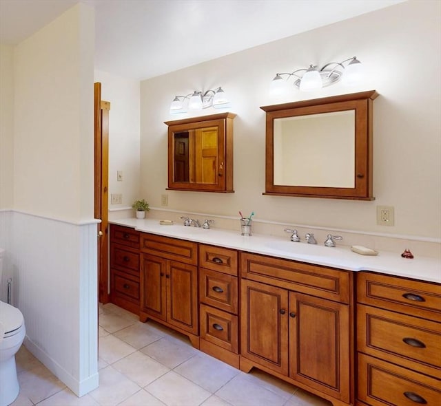 131 Sandgully Rd N, Deerfield, MA 01373 - full bathroom featuring double vanity, toilet, tile patterned floors, and wainscoting