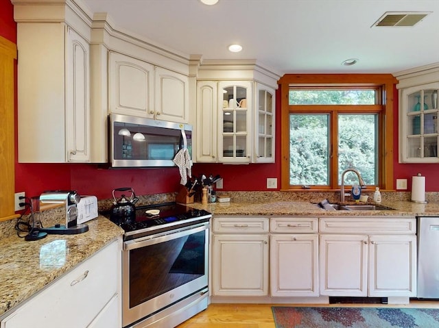 131 Sandgully Rd N, Deerfield, MA 01373 - kitchen with stainless steel appliances, a sink, cream cabinetry, light stone countertops, and recessed lighting