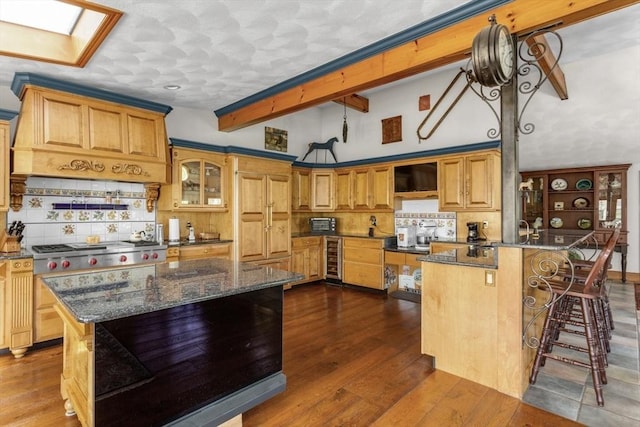 78 Daniels St, Franklin, MA 02038 - kitchen featuring wine cooler, tasteful backsplash, a breakfast bar, a peninsula, and dark stone countertops