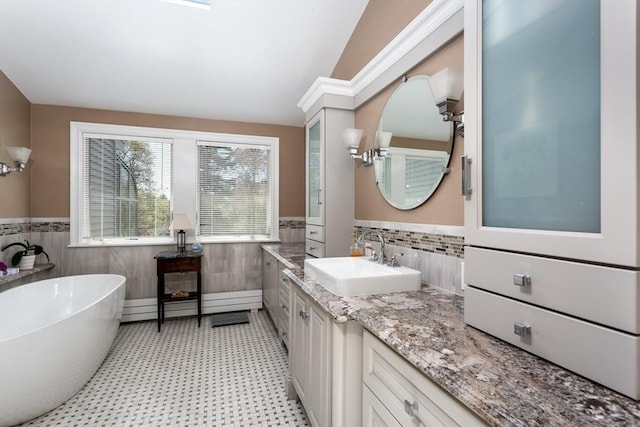 78 Daniels St, Franklin, MA 02038 - full bath featuring tile walls, wainscoting, a freestanding bath, tile patterned floors, and vanity