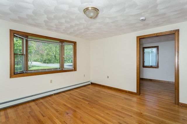 78 Daniels St, Franklin, MA 02038 - empty room featuring baseboard heating, light wood-style flooring, and baseboards