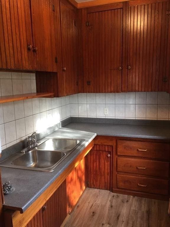 13 Elm St, Webster, MA 01550 - kitchen with backsplash, light wood finished floors, brown cabinetry, and dark countertops
