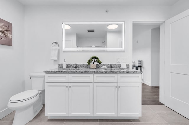 bathroom featuring tile patterned flooring, vanity, and toilet