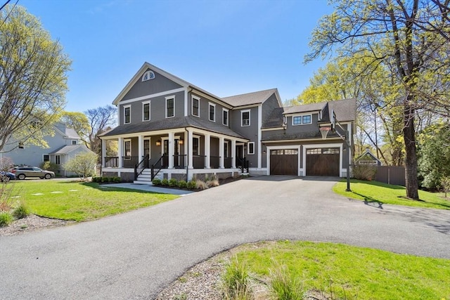 view of front of property with covered porch, an attached garage, driveway, and a front lawn