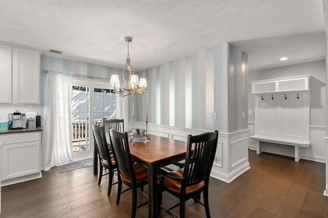 dining space with dark wood-type flooring and a chandelier