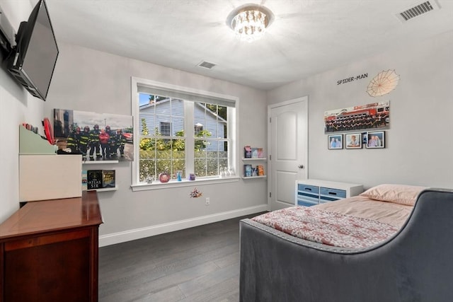 bedroom with dark hardwood / wood-style floors and a notable chandelier