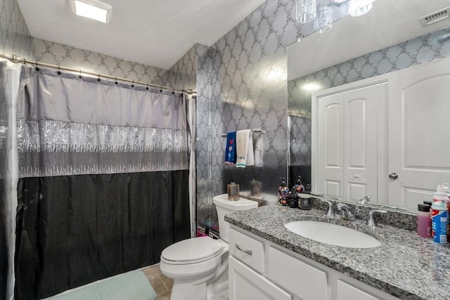 bathroom with toilet, vanity, walk in shower, and tile patterned flooring