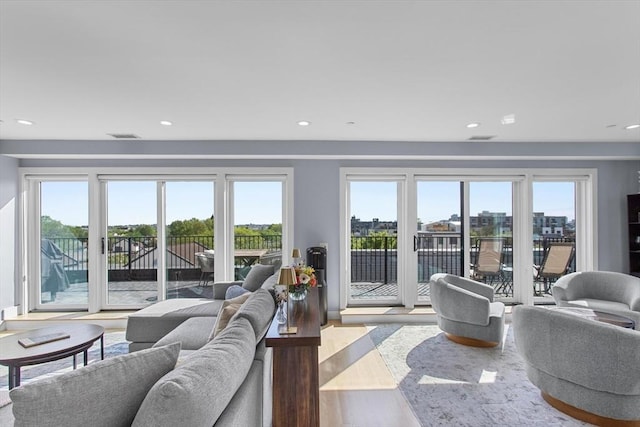 living room featuring plenty of natural light, wood finished floors, and recessed lighting