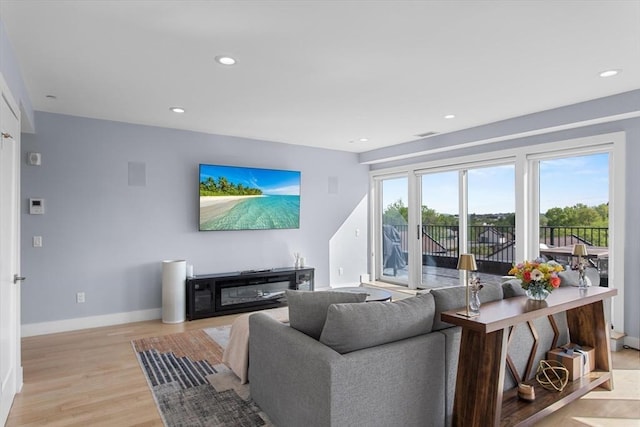 living area featuring baseboards, light wood-style floors, and recessed lighting