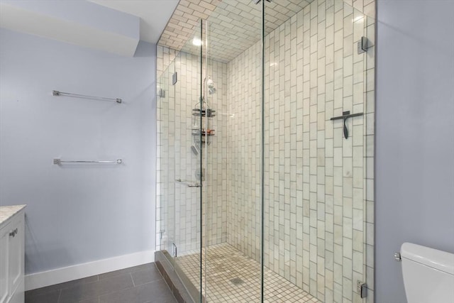 bathroom featuring a shower stall, tile patterned floors, toilet, baseboards, and vanity