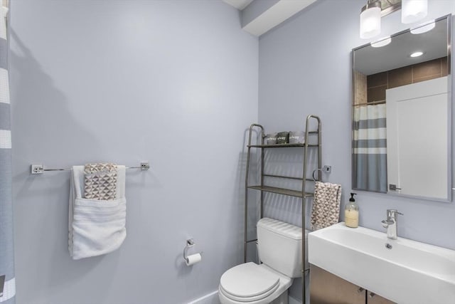 bathroom with a sink, toilet, baseboards, and a shower with curtain