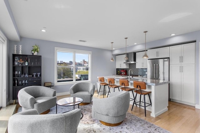 living area with light wood-style floors, recessed lighting, and baseboards
