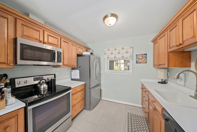 kitchen with sink, stainless steel appliances, and a textured ceiling