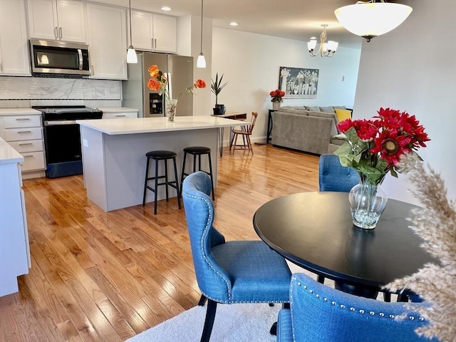 215 High St Unit 18, Taunton, MA 02780 - kitchen featuring light countertops, a kitchen bar, light wood-type flooring, and appliances with stainless steel finishes