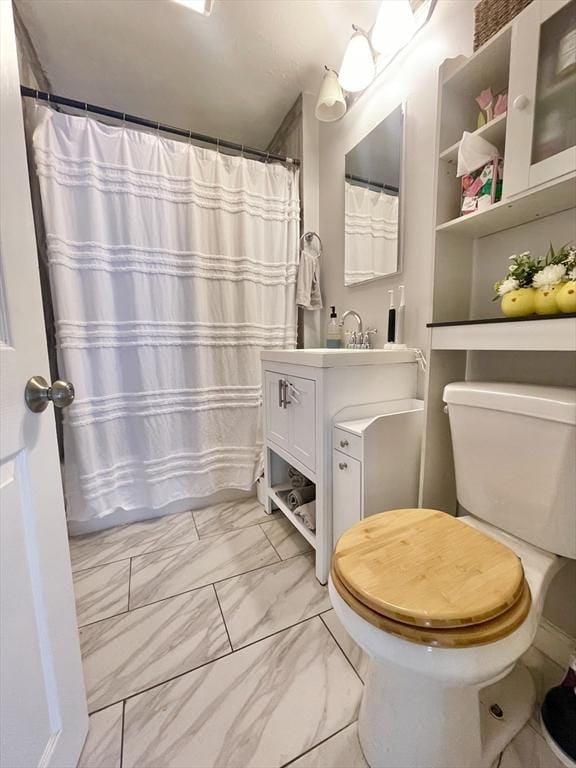 bathroom featuring marble finish floor, curtained shower, vanity, and toilet