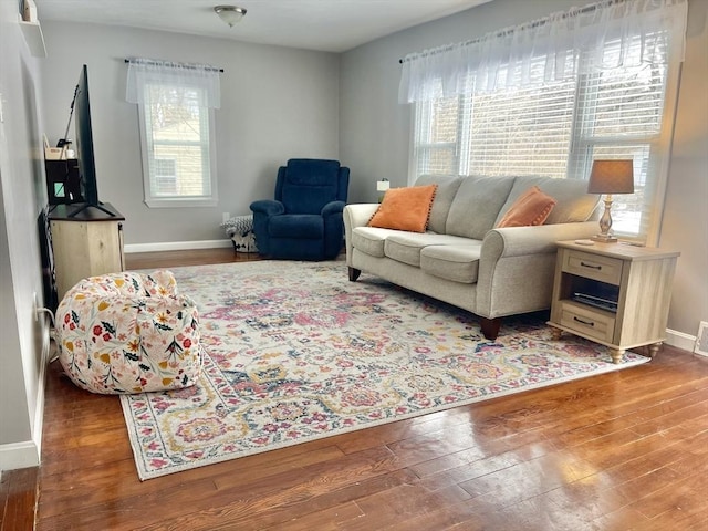 living room featuring hardwood / wood-style flooring, visible vents, and baseboards